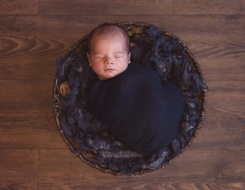 Baby newborn boy in basket navy blue