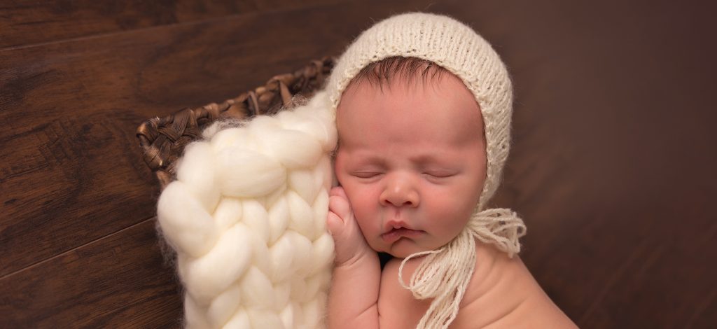 Newborn Baby with cream bonnet sleeping session portrait photo