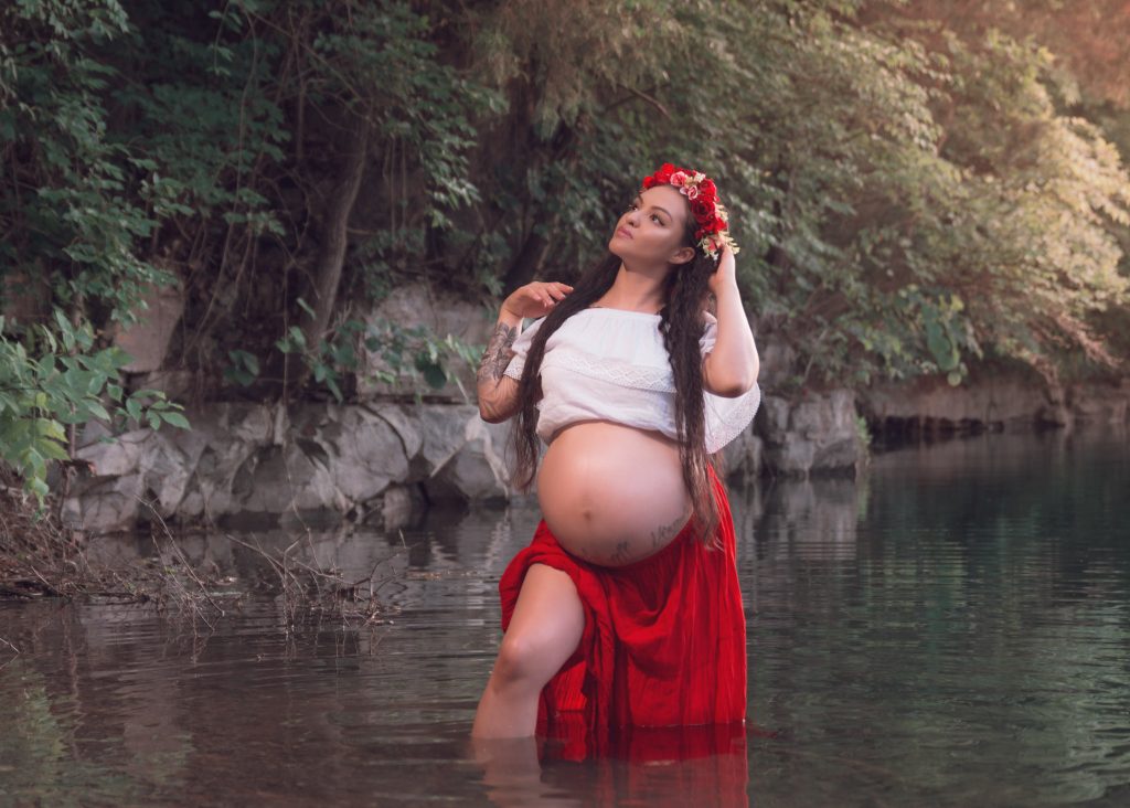 Mexican-themed Cultural Tribal Maternity dress shoot in Clarksville Tennessee TN red dress in the woods trees in the water at sunset
