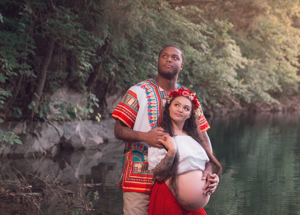 Mexican-themed Cultural Tribal Maternity dress shoot in Clarksville Tennessee TN red dress in the woods trees in the water at sunset couple husband and wife