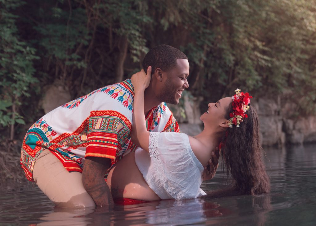 Mexican-themed Cultural Tribal Maternity dress shoot in Clarksville Tennessee TN red dress in the woods trees in the water at sunset couple husband and wife dip leaning back funny laughing