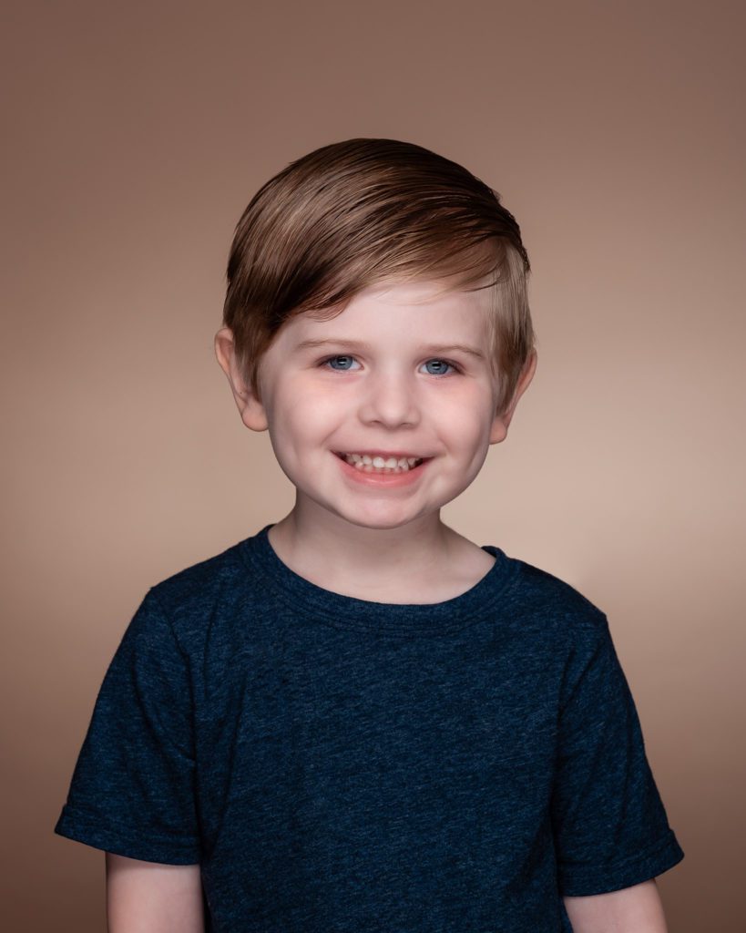 5 year old boy portrait photographed in photo studio with savage mocha seamless paper