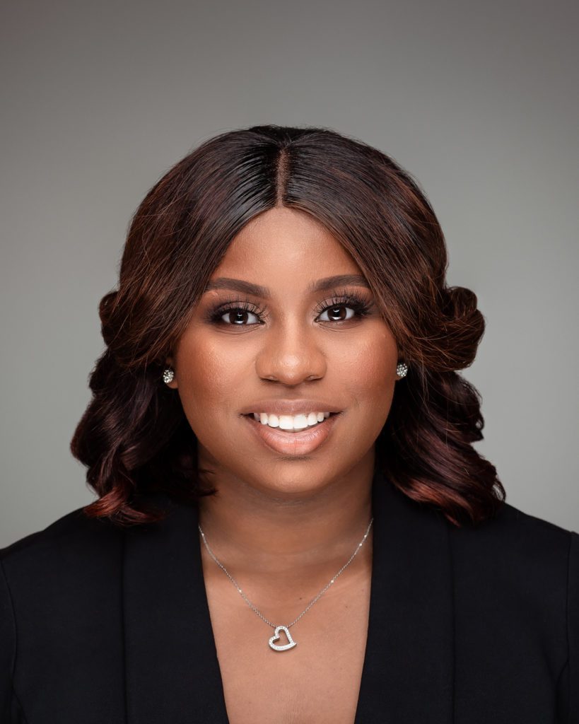 Business photo portrait of beautiful black woman in a black jacket on gray background