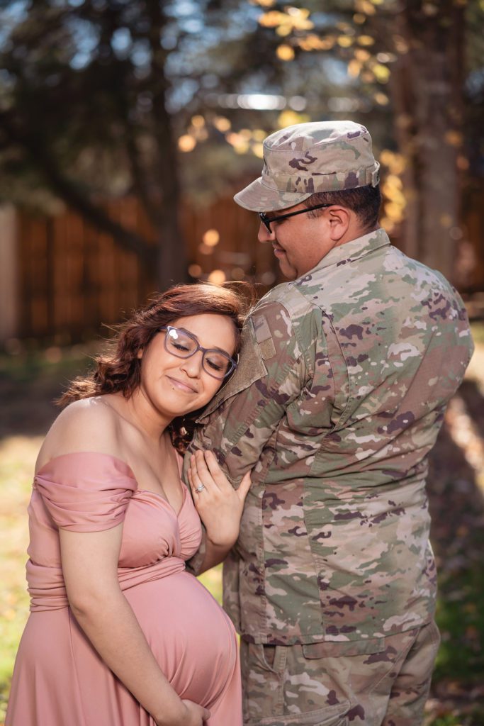 maternity photos outside with husband in army military uniform.