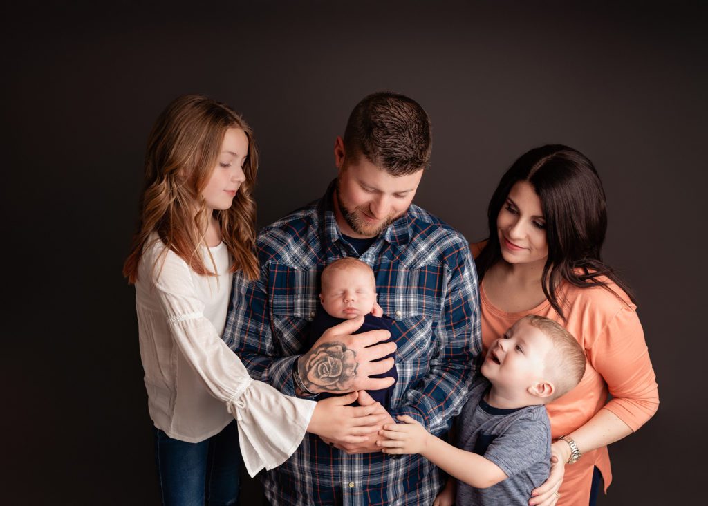 studio newborn photography session with family of 5 with savage thunder gray backdrop