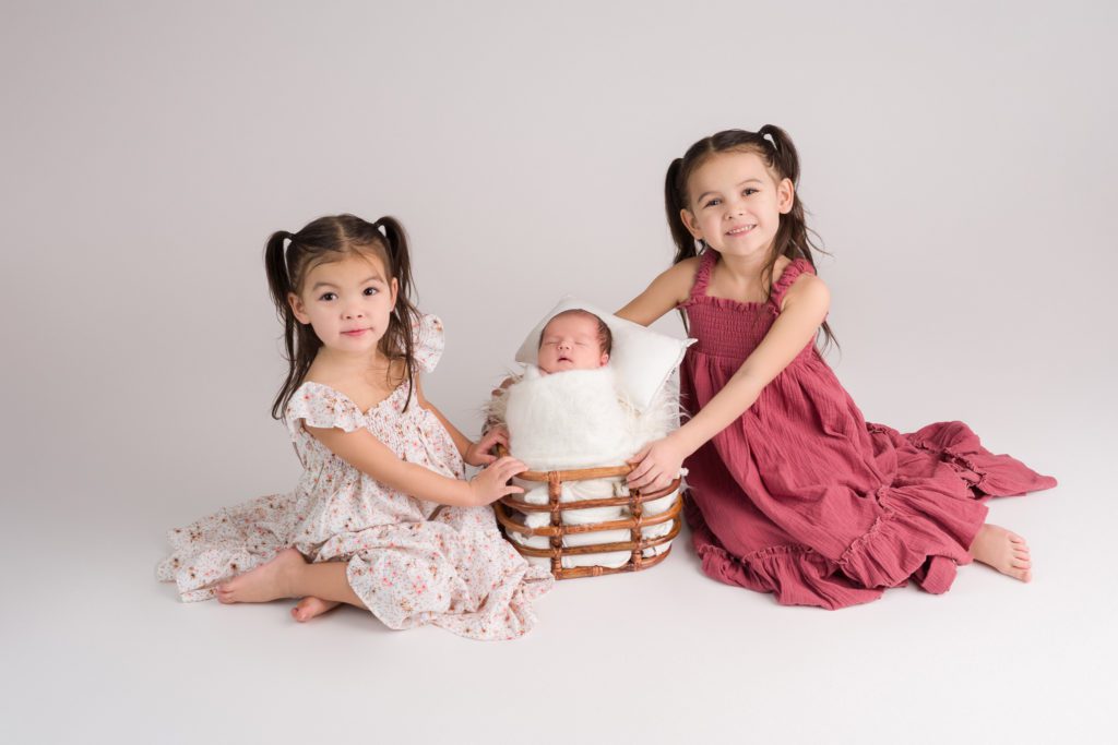 Newborn session with two sisters on white backdrop