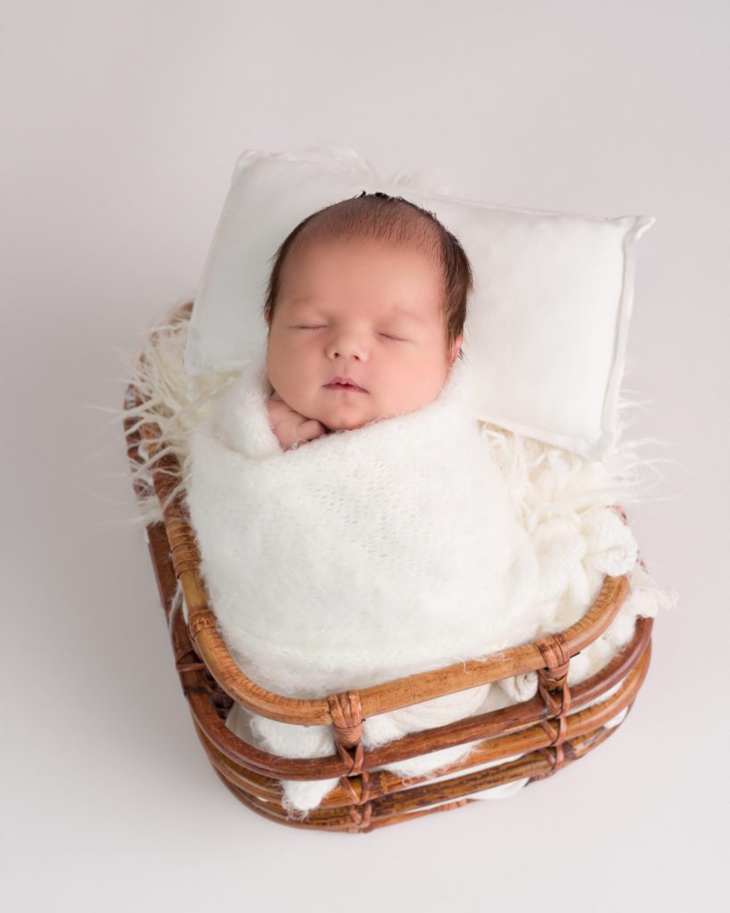 Newborn baby boy wrapped in white sleeping