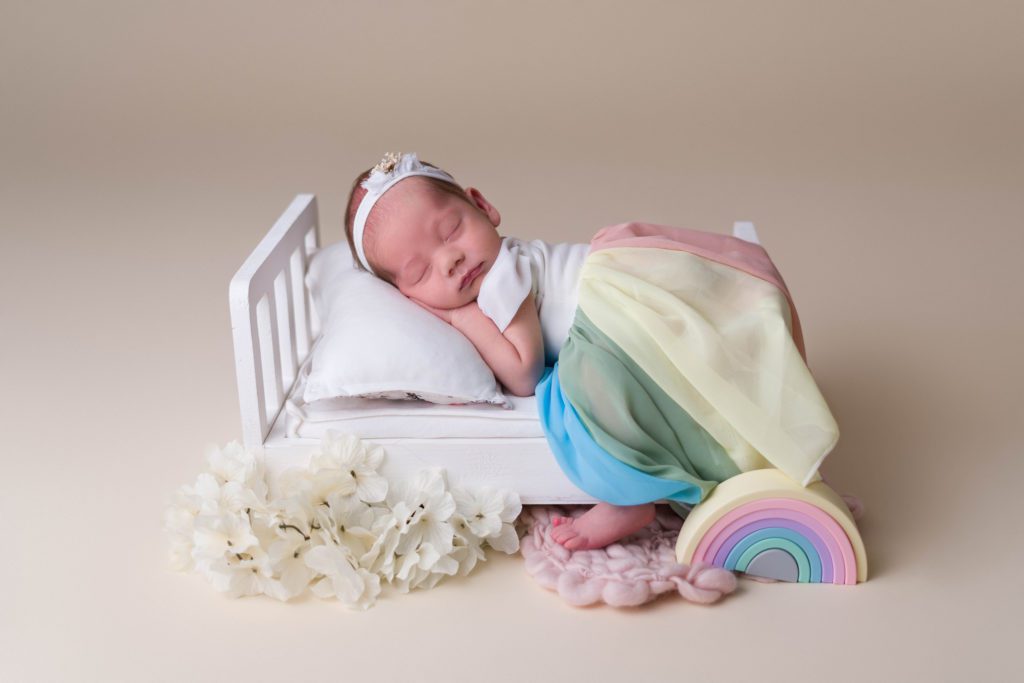 Rainbow baby girl sleeping with newborn chicaboo dress